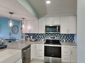 A modern kitchen with white cabinets, a stainless steel oven, and a microwave. - Bright, Updated Love's Coastal Villa Retreat w/ Heated Pool & Resort Perks (Panama City Beach)