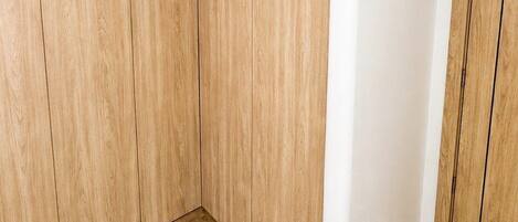 Una stanza d'angolo con pareti in legno a pannelli, un pilastro bianco e un pavimento piastrellato.