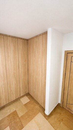 A corner room with wooden panel walls, a white column, and a tiled floor. - Stylish Kennedy Norte | Near Parque Lineal (Guayaquil)