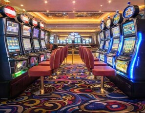 A casino floor with slot machines and red bar stools. - Amazing experience with ocean views on Balboa Ave 2 (Panamá)