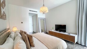A hotel room with a bed, a TV, a bedside table, a lamp, and a mirror. - Amazing experience with ocean views on Balboa Ave 2 (Panamá)