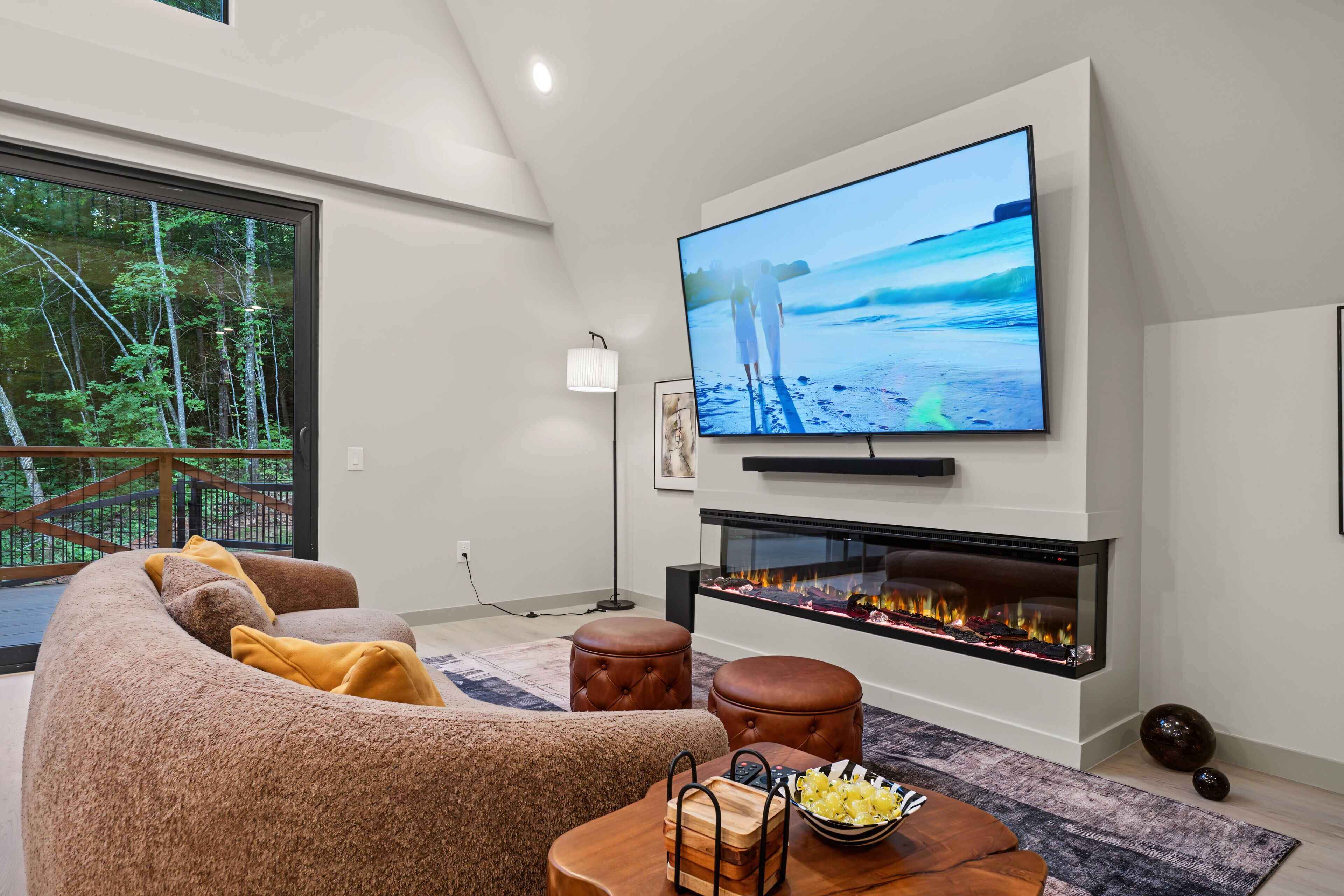En moderne stue med et fladskærms TV, en pejs, en sofa og et spisebord.