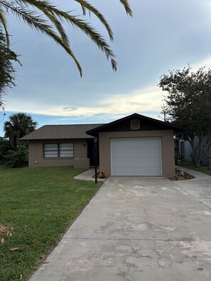 A residential house with a garage, a lawn, and a driveway. - Cozy 2-bedroom house in peaceful Hernando Beach with Dock (Hernando Beach)