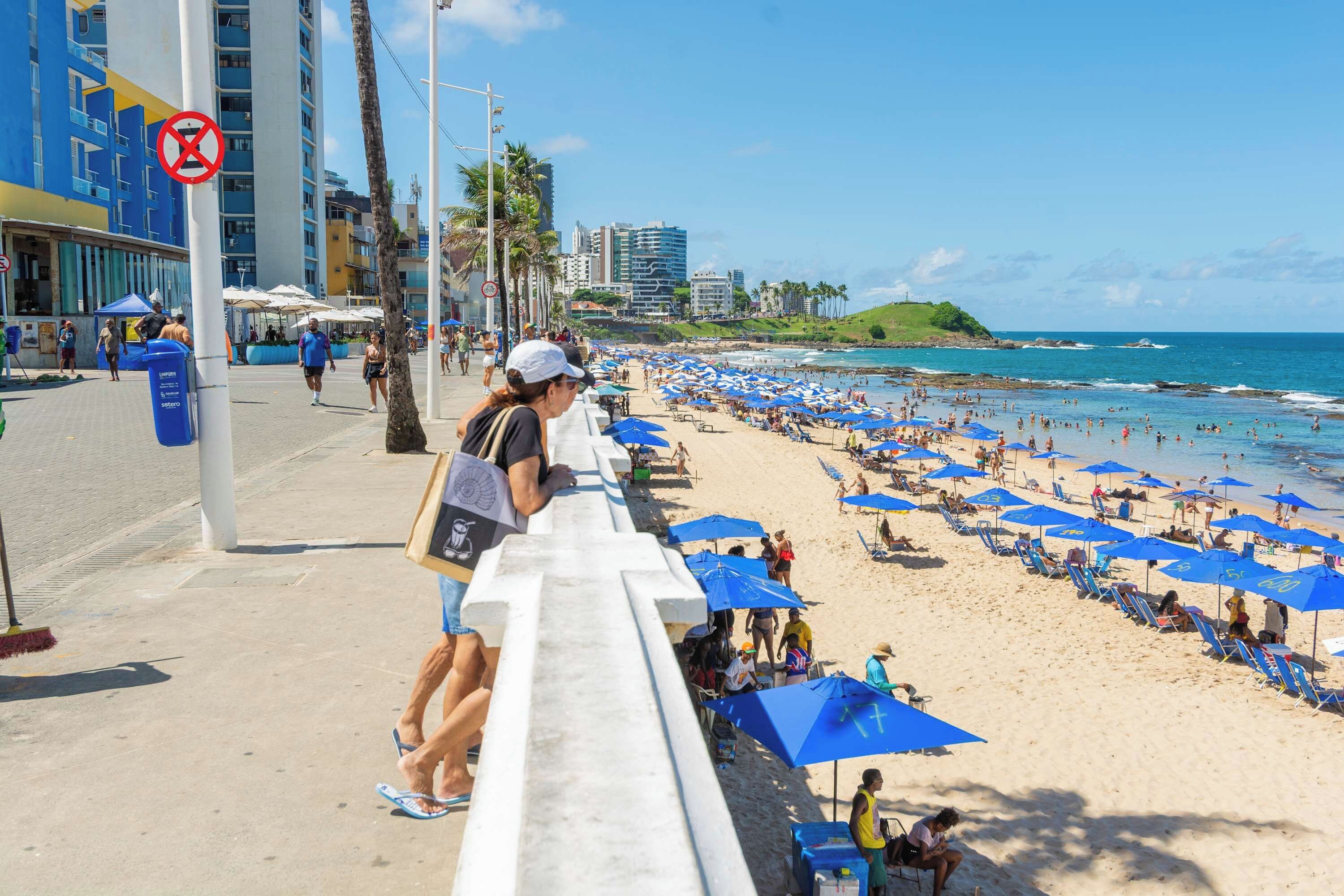 A beach with umbrellas and people.
