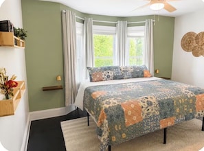 A bedroom with a bed, curtains, a window, and a ceiling fan. - Edgewater Escape (Cleveland)