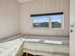 A room with a bed, a window, and a door. - "Nuka" - 250m from the sea by Interhome (Hjørring)