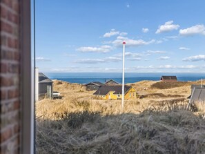 Een kustlandschap met huizen, een wimpel en uitzicht op de zee.
