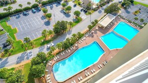 Un resort con due piscine, un parcheggio e vista sulla zona circostante.