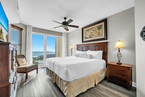 A hotel room with a bed, a chair, a nightstand, a ceiling fan, and a window with a view. - Gulf Views~Seascape Resort~Large Condo~ARD1701 (Miramar Beach)