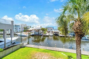 A marina with boats docked, a wooden pier, and modern buildings with balconies. - Joy by the Sea - Large Home w/ Harbor Views - Pet Friendly & Private Dock (Destin)