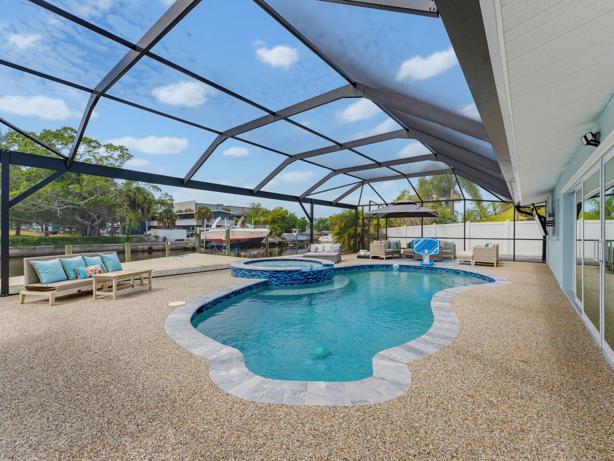 Piscina ao ar livre coberta, com uma cesta de basquete integrada, cercada por espreguiçadeiras e um espaço de terraço.