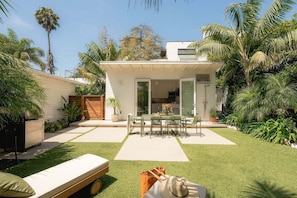 Ein modernes Haus mit Terrasse, Essbereich und Garage.