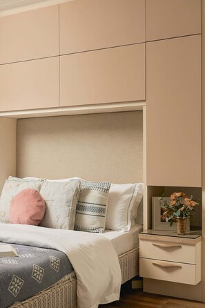 Ein Schlafzimmer mit einem Bett, Kissen, einem Nachttisch und einem Beistelltisch.