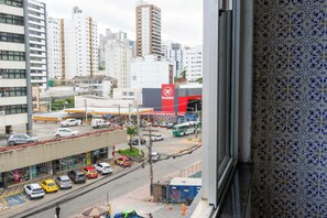 Eine Stadtstraße mit Gebäuden, einer Shell Tankstelle und geparkten Autos.