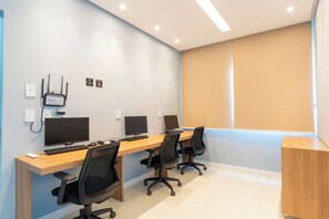 A modern office space with three desks, each with a computer monitor, keyboard, and office chair. - 2BR at Corsário Beach | Pool & A/C (Salvador)