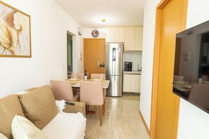 A compact living space with a kitchenette, a dining area, and a seating area with a sofa and chairs. - Ocean View at Corsário Beach | Pool & A/C (Salvador)