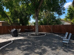 A backyard with a tree, a barbecue grill, and outdoor seating. - 5 Min to Lackland BMT-Near Downtown- Pet Friendly (San Antonio)
