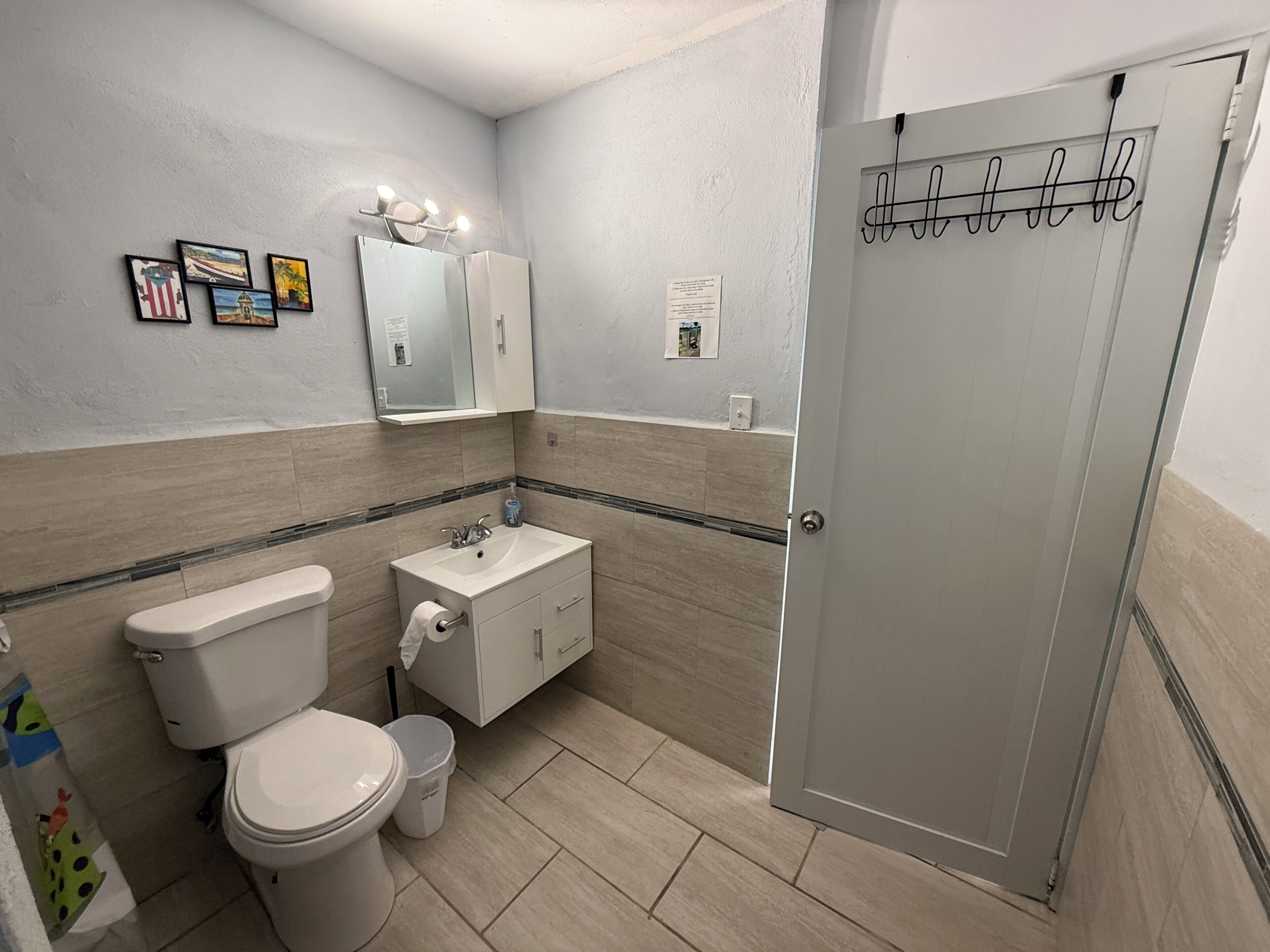 A bathroom with a toilet, sink, and shower area.