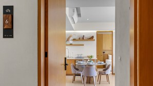 Un interno moderno con zona pranzo, cucina e una porta in legno con una targa numerica.