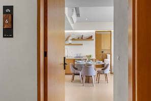 Ein modernes Interieur mit Essbereich, Küche und einer Holztür mit Nummernschild.