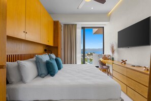 Ein Hotelzimmer mit Bett, Schreibtisch, Fernseher und Meerblick.