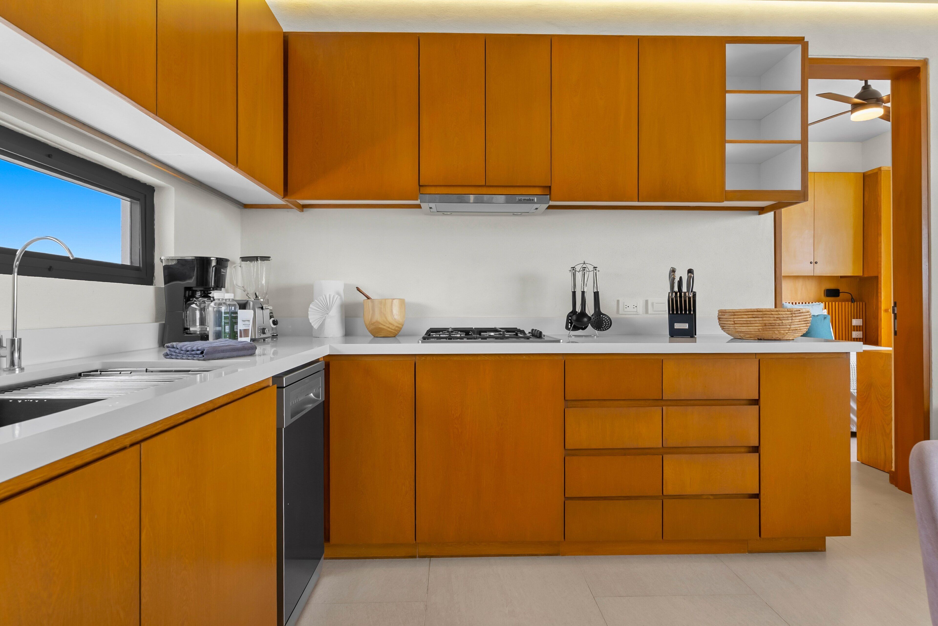 Una cocina moderna con armarios de madera, horno empotrado y ventana.