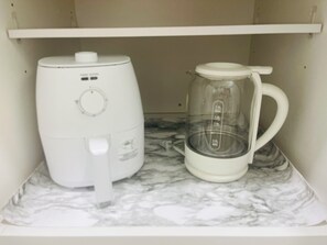 A white coffee maker and a glass carafe on a marble countertop. - Little Piece of Paradise (Tampa)