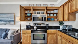 Una cocina moderna con armarios de madera, electrodomésticos de acero inoxidable y una encimera de granito.
