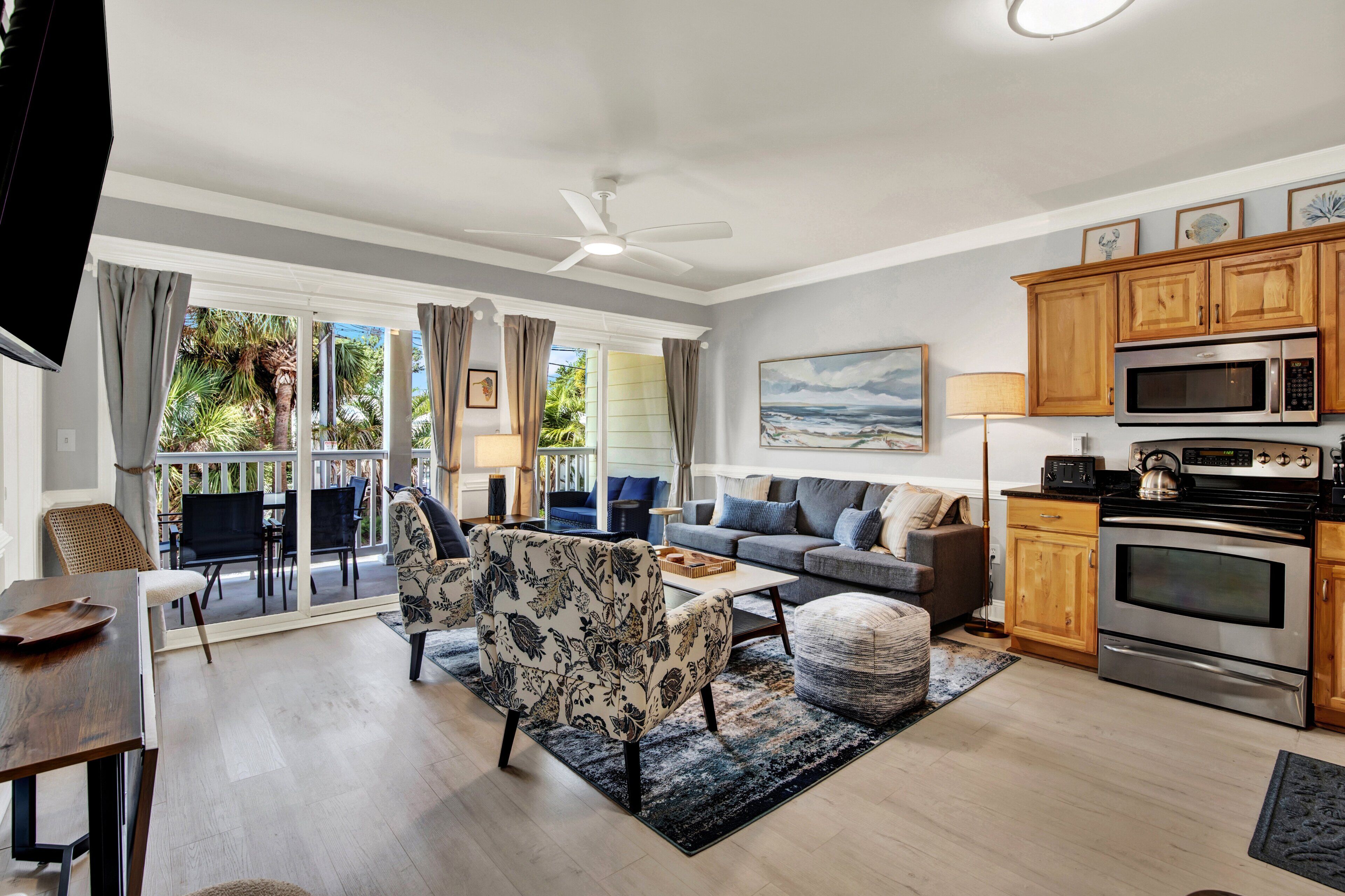 A modern living room with a sofa, chairs, a coffee table, and a view of the outdoors.