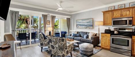 A modern living room with a sofa, chairs, a coffee table, and a view of the outdoors.
