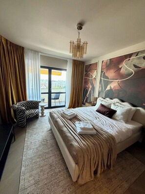 Een moderne slaapkamer met een groot bed, een stoel met zebrapatroon, een kleine tafel en uitzicht op de stad door een schuifdeur.