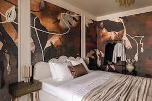 A bedroom with a bed, a nightstand, a wall-mounted clothing rack, and a decorative vase. - Velvet Noir Old Town (Bucharest)