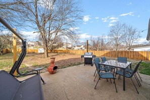 An outdoor patio with a table and chairs, a grill, and a decorative pot. - Hudson House | 0.2 Miles to Red River (1726 Broadripple Drive) (Clarksville)