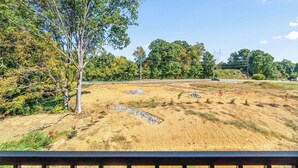 A dirt field with sparse vegetation and a single tree. - 19th Hole Haven in Sango (1625 Golf Club, #601) (Clarksville)