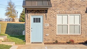 Un edificio di due piani con una porta azzurra e il numero 801 sulla parete.