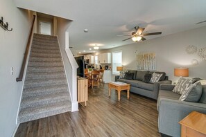 A spacious living area with a staircase, a dining area, and a kitchen. - Downtown Duo on Franklin (1010 Franklin St) (Clarksville)