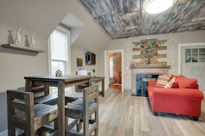 Ein Loft-Zimmer mit Essbereich, einem roten Sofa und einem Kamin.