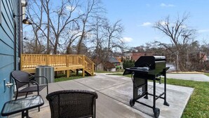 Eine Terrasse mit Gartenmöbeln, einem Grill und einem Holzdeck.