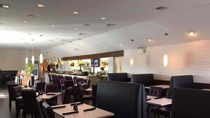 A restaurant with booths and tables, a counter with a menu, and a modern interior design. - Hometown Clarksville Cottage (1021 Crossland Ave) (Clarksville)