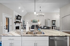 A modern kitchen with a marble countertop, stainless steel appliances, and pendant lighting. - The Clubhouse on Colston (2296 Colston Dr) (Clarksville)