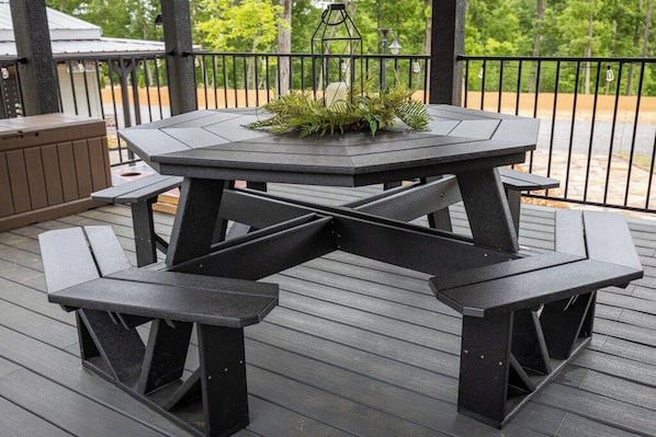 A dark wooden deck with a hexagonal table and benches. - The Nesting Nook (In The Pines at KY Lake) (Dover)