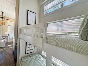 Ein Etagenbett mit Fenster, Deckenventilator und einem Bild von einem Fisch an der Wand.