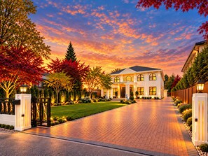 A large, two-story house with a driveway leading to the entrance, surrounded by trees and well-maintained landscaping. - Breezery Retreat (Richmond)