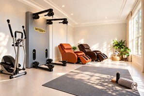A gym with exercise equipment, a massage chair, and a yoga mat. - Breezery Retreat (Richmond)
