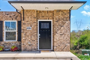 A brick building with a black door and a number 606 sign. - Birdie's Nest on Golf Club (1625 Golf Club Ln) (Clarksville)
