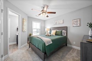A bedroom with a bed, a ceiling fan, a window, and a door. - Birdie's Nest on Golf Club (1625 Golf Club Ln) (Clarksville)