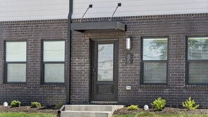A modern two-story building with a dark brick facade, a front door with a glass panel, and three windows with blinds. - River's Edge (111 Hickory Grove BLVD) (Clarksville)