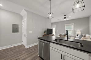 A modern kitchen with a stainless steel dishwasher, a black countertop, and a built-in sink. - River's Edge (111 Hickory Grove BLVD) (Clarksville)