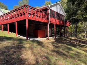 A red metal structure with a covered area, possibly a garage or workshop, adjacent to a building with a white roof.