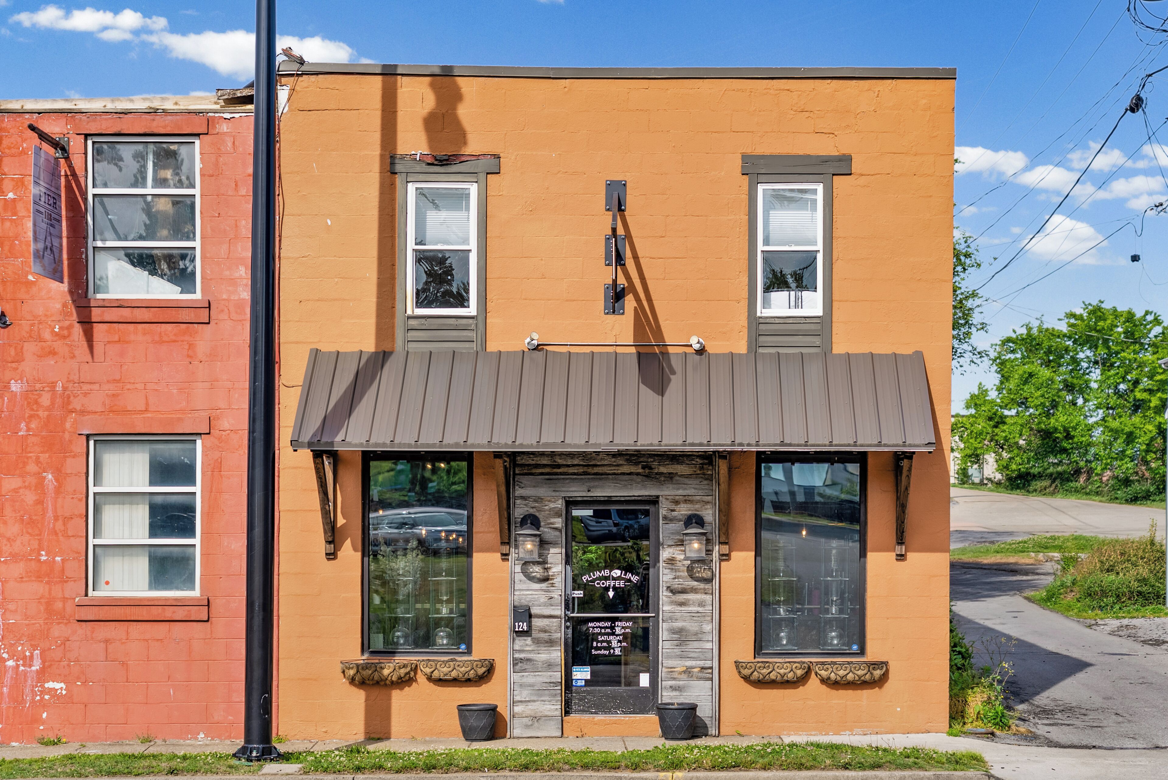 A building with a storefront, a signboard, and a door with a window.